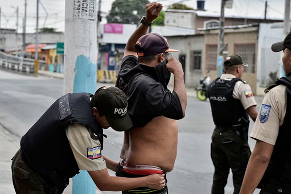 Полицейский обыскивает мужчину в Эквадоре (09.01.24)(2024)|Фото: Reuters / Vicente Gaibor del Pino