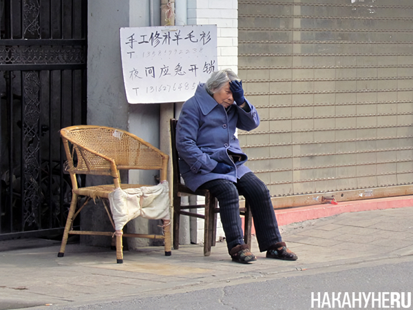 Женщина в Шанхае держится за голову (фото 2012 года)(2024)|Фото: Накануне.RU