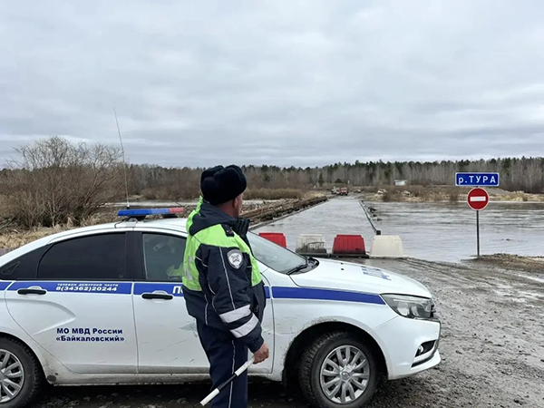 Сотрудник полиции перед разрушенным паводком мостом через реку Тура в Свердловской области(2026)|Фото: Управле­ние Госавтоинспекции ГУ МВД России по Св­ердловской области