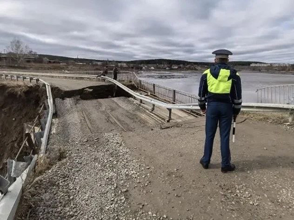Сотрудник полиции перед разрушенным паводком мостом через реку Тура в Свердловской области(2026)|Фото: Управле­ние Госавтоинспекции ГУ МВД России по Св­ердловской области